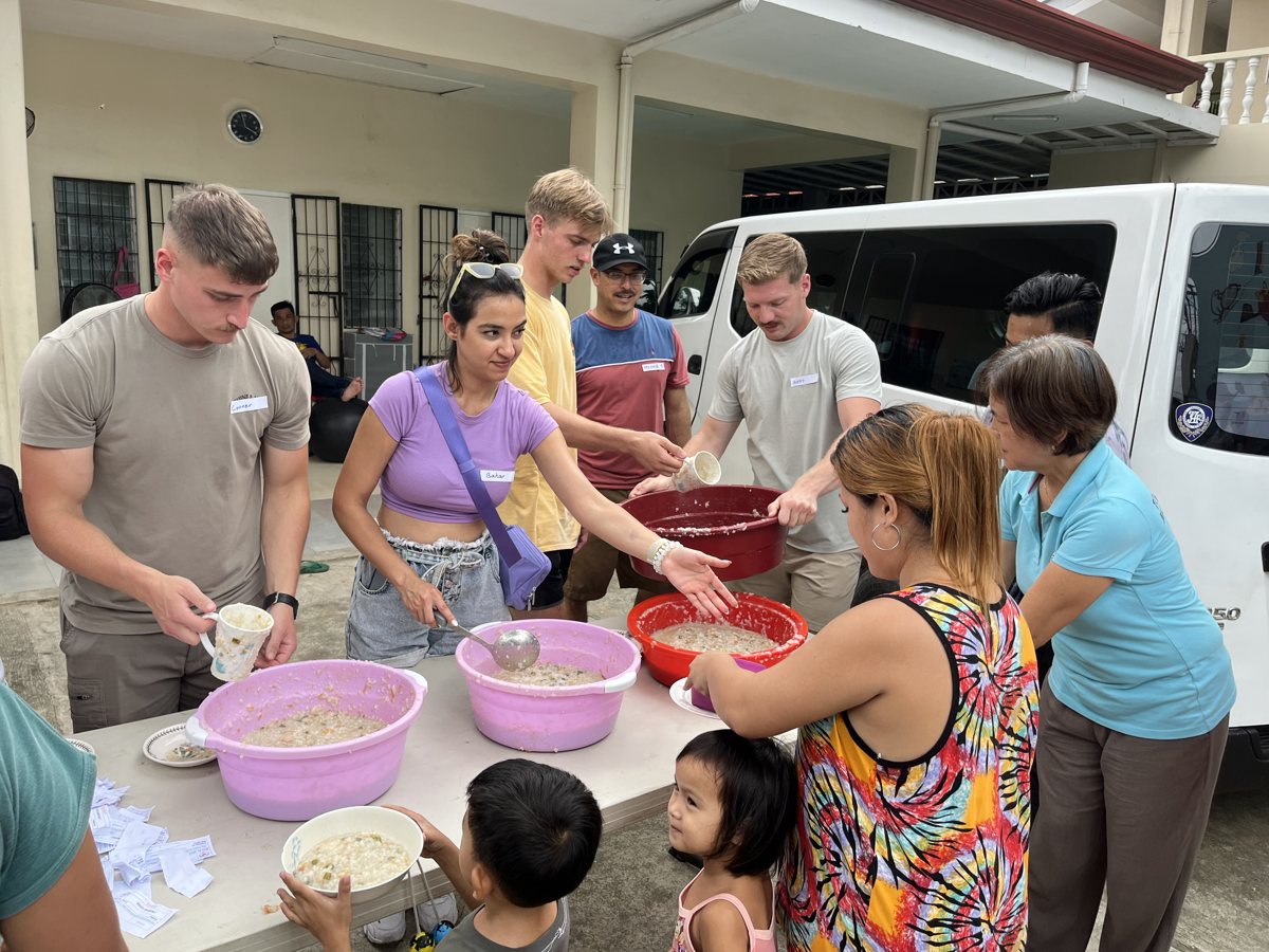 Fatemeh Naderi serving food at a community food-sharing event in Cebu, Philippines